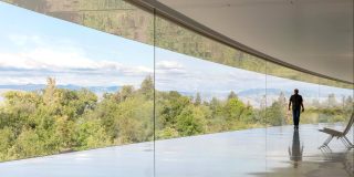 Apple layoffs avoided | Man walking inside Apple Park campus