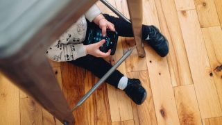 App Store has hundreds of 'risky' apps rated as appropriate for kids | Young child unlocking an iPhone