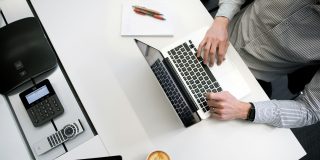 Hyper-personalized phishing attacks, powered by AI | Man typing on MacBook