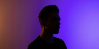 Reddit lets you tailor your profile to subreddits, inc hiding NSFW content | Person silhouetted against colorful background