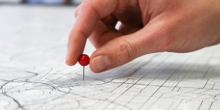 Many Gen Z use Find My and other apps to share their location with friend groups 24/7 | Photo shows a hand placing a pin in a map