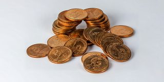 Why Apple is fighting legal battles in two countries over 12 cents per iPhone | A pile of coins on a table