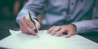 Just one word in the Google antitrust ruling was worth $20B a year to Apple | Close-up photo of a man amending a contract