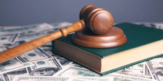 Apple seeking permission to appeal loss in $1B+ developer lawsuit | Photo shows court gavel and book on top of a pile of $100 bills