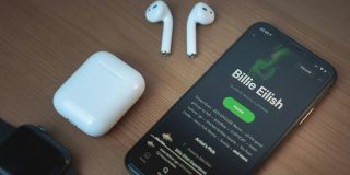 Pirate group says it has scraped almost the whole of Spotify | Spotify app seen on an iPhone alongside AirPods and an Apple Watch