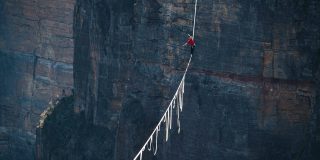 Apple needs to walk a tightrope as it plans to boost subscription services | A highline walker in the Blue Mountains