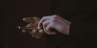 Pornhub is now using Apple's own age verification feature in the UK | Close up of a man using an iPhone