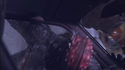 Kamen Rider Kuuga's Yusuke smashing a villain's head into a car window.
