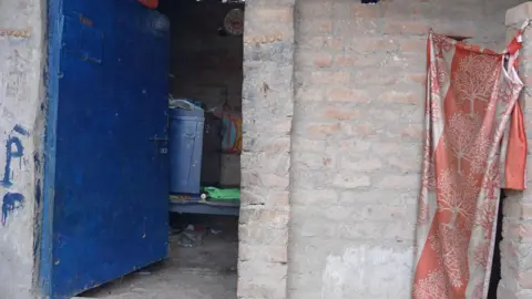 Shahnawaz Ahmad The survivor's one-room house with the bathroom covered with a cloth curtain