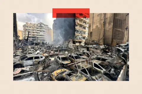Anadolu via Getty Images Emergency teams work at the scene where smoke rises from targeted locations across Lebanon - destroyed cars and buildings are shown
