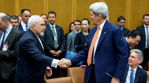 Thomas Imo/Photothek via Getty Images Foreign Minister of Iran, Mohammad Javad Zarif shakes hands with US Secretary of State John Kerry at the last working session of negotiations on July 14, 2015 in Vienna, Austria