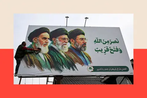 AFP via Getty Images A man cleans a billboard featuring Iran's late supreme leaders Ayatollah Ruhollah Khomeini (L) and Ayatollah Ali Khamenei (C) next to newly elected supreme leader Ayatollah Mojtaba Khamenei