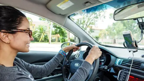 Getty Images A female Uber driver in Miami Beach, Florida, driving 