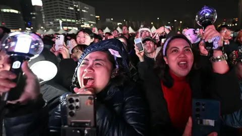 Getty Images BTS fans react as they watch the comeback concert of K-pop boy group BTS