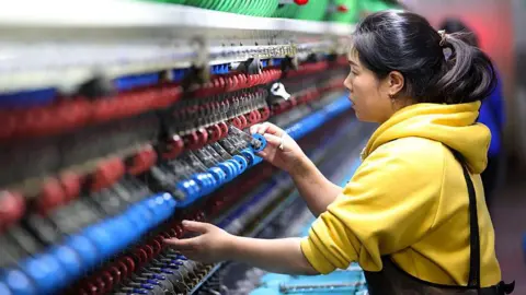 Getty Images An employee operates a machine at a silk production enterprise on November 17, 2025 in Chongqing, China