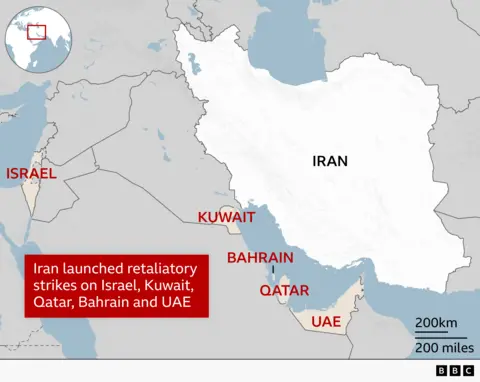 ALT TEXT: A regional map highlighting Iran in white with its name in black. Countries that have come under fire from Iran are labelled in red - Israel, Kuwait, Bahrain, Qatar, UAE. Surrounding countries are grey.