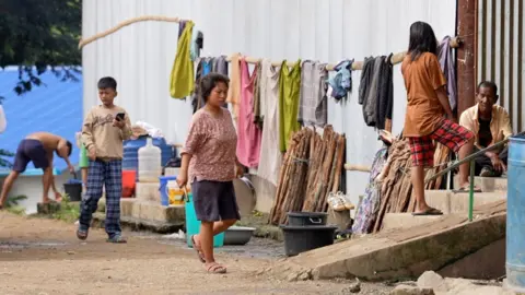 Midhat Ullah Hasani People carrying on with their daily lives outside a displacement camp in Manipur