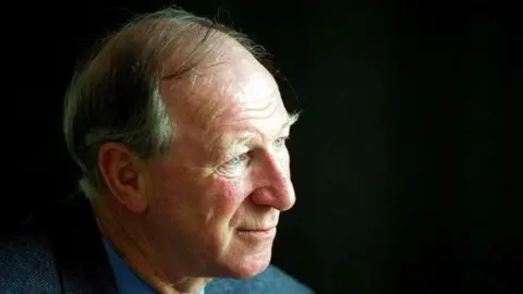 Getty Images Jack Charlton, a man with grey hair, wearing a grey jacket and blue shirt.