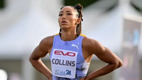 LightRocket/Getty Images Shania Collins of United States reacts after competing in a 100m race - she has her hands on her hips and is wearing a light purple vest.