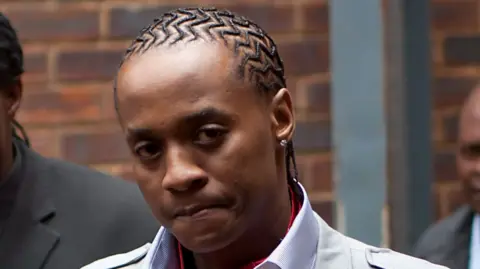 Getty Images Molemo "Jub Jub" Maarohanye looks at the camera. He wears a shirt, jacket and cornrows.