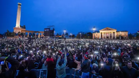 AFP via Getty Images A large crowd of people at dusk