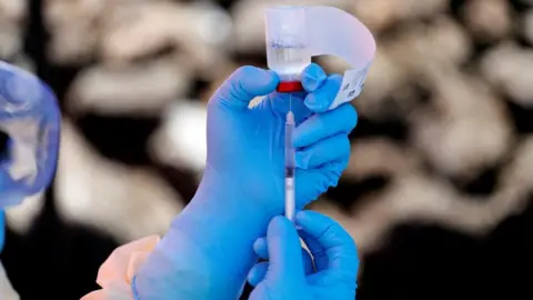 Reuters A health worker fills a syringe with Ebola vaccine 