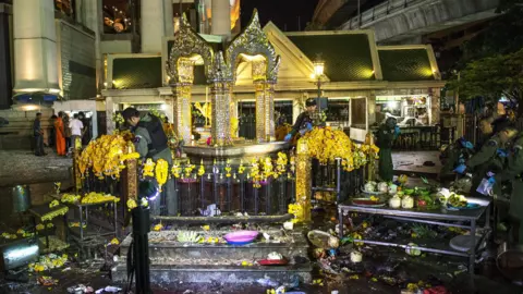 Reuters Thai police officers, investigators working at the shrine surrounded by debris and the remains of religious offerings of fruit and flowers, 17 Aug 2015