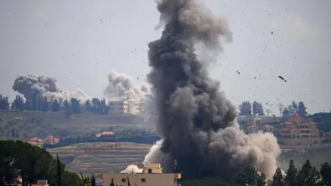 Reuters Smoke billows following Israeli air strikes in the Nabatieh area, southern Lebanon (2 June)
