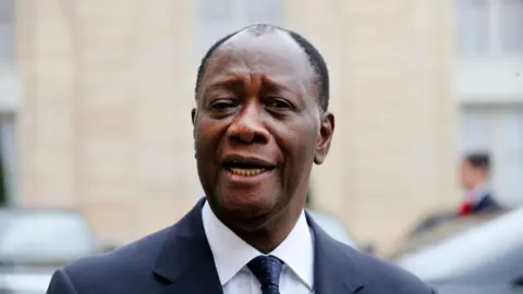 Getty Images President Alassane Ouattara is pictured looking at the camera, wearing a suit and tie