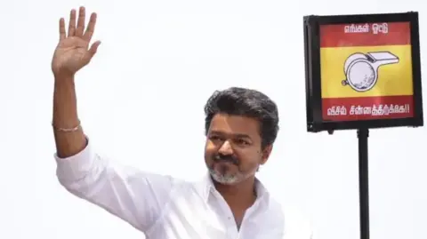 TVK Indian actor and Tamilaga Vettri Kazhagam (TVK) party president C. Joseph Vijay seen holding up the party symbol during an election rally in April
