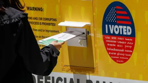 Getty Images A person places their Mail in ballot into a ballot box during early voting outside of the LA County Registrar-Recorder building on 1 June 2026 in Norwalk, California.