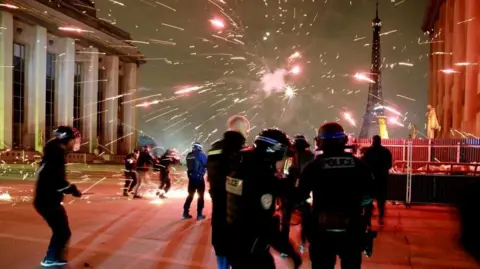 Reuters Police face a barrage of fireworks near the Eiffel Tower