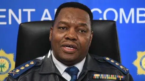 Gallo via Getty Images South Africa's national police commissioner Fannie Masemola is seen in uniform at a press briefing