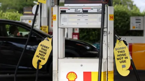 Reuters Signs displayed on empty fuel dispensers at a Shell petrol station say 'Sorry this hose is not in use' in Sydney, Australia