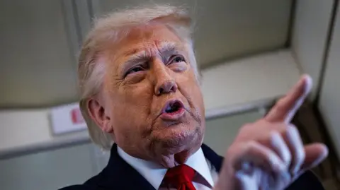Getty Images Close up shot of Trump stood pointing while speaking to reporters on Air Force One