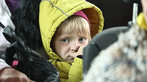 Getty A woman and her daughter evacuated from a northern border settlement of Kharkiv Oblast wait in an evacuation bus for departure to Kharkiv city