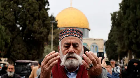 Reuters Muslim man prays outside the Dome of the Rock at the start of Ramadan 2025