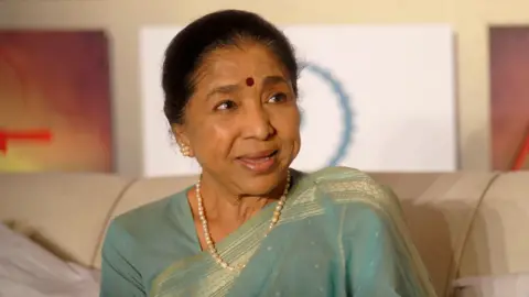 AFP via Getty Images Asha Bhosle wearing a blue saree attends an event for the film 'Maaee' in Mumbai on April 27, 2011 in Mumbai, India