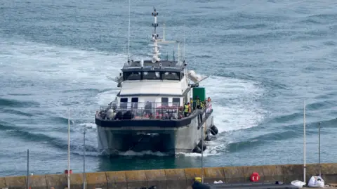 PA Media A photo of a group of people thought to be migrants are brought in to the Border Security Command compound in Dover, Kent, onboard a Border Force vessel following a small boat incident in the Channel