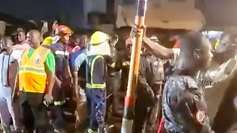 Ghana National Fire Service/X A crowd around the site of the collapsed building