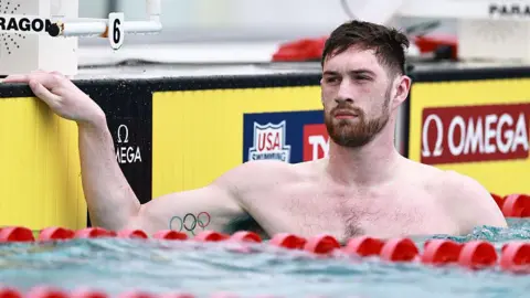 Getty Images Hunter Armstrong in a swimming pool, with his hand on the the poolside.