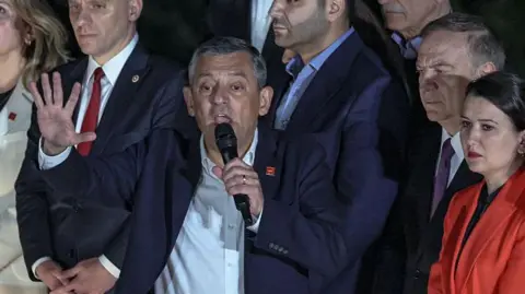 AFP via Getty Images Özgür Özel addresses crowds in Ankara