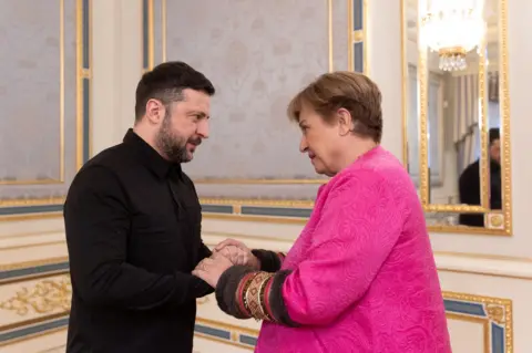 Reuters Volodymyr Zelensky, dressed in a black shirt, welcomes Kristalina Georgieva in Kyiv has the two talk over their clasped hands