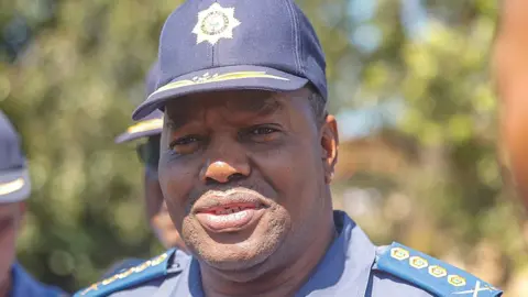 Gallo Images via Getty Images A head and shoulders image of Fannie Masemola in a police cap. His blue uniform's epaulets can be seen.