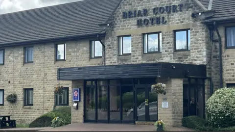 The entrance to a hotel. A sign above the door says: Briar Court Hotel.
