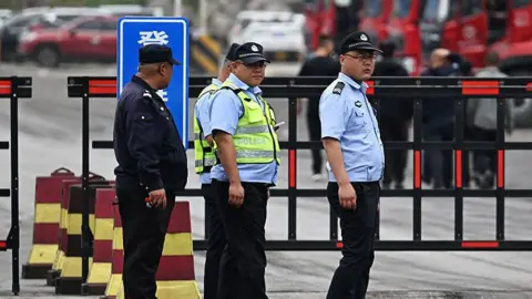 Getty Images Police guard the road outside the Liushenyu coal mine, where an explosion killed dozens in Qinyuan county, in China's northern Shanxi province on May 24, 2026. 