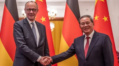 EPA Friedrich Merz and Premier of China Li Qiang shake hands at the Great Hall of the People in Beijing