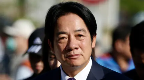 Getty Images William Lai wears a dark coloured suit and white collared shirt