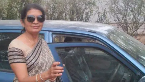 An Indian chemistry teacher called Mamta Pathak is wearing a sari, and standing outside a car in this undated picture.