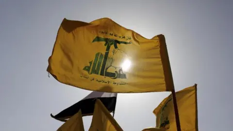 Reuters A file photo of a Hezbollah flag with the sun behind it 